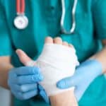 Healthcare professional bandaging hand